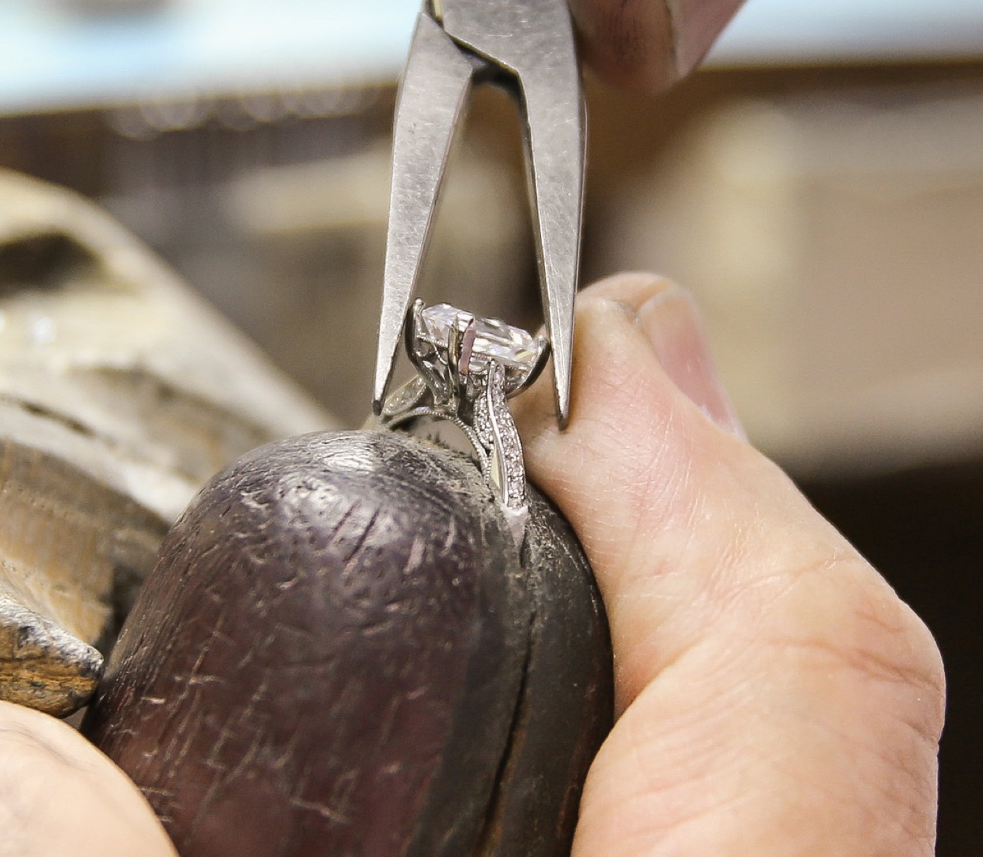 a jewelery craftsman examining a diamond ring